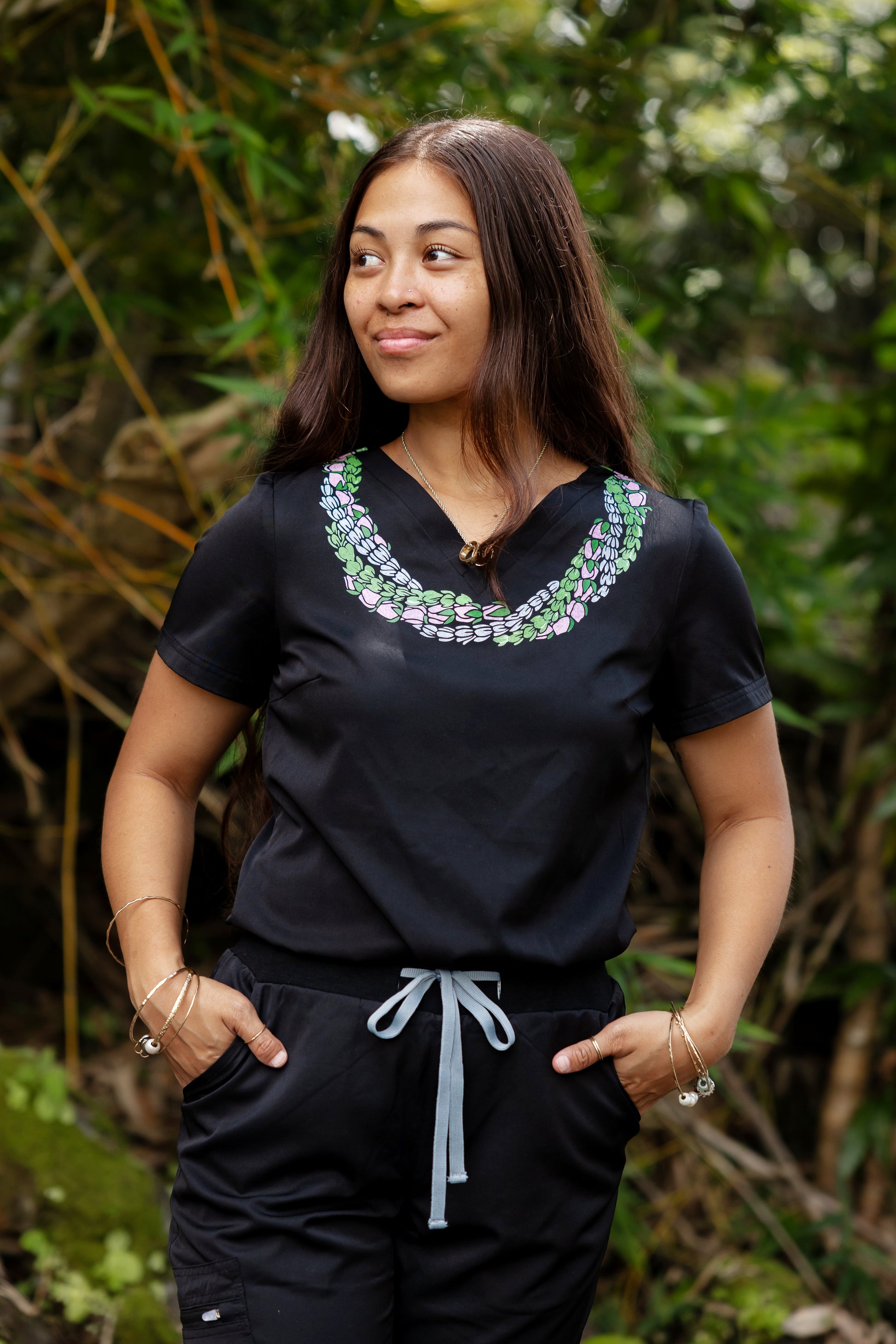 Woman wearing medical scrub top with Hawaii inspired lei design