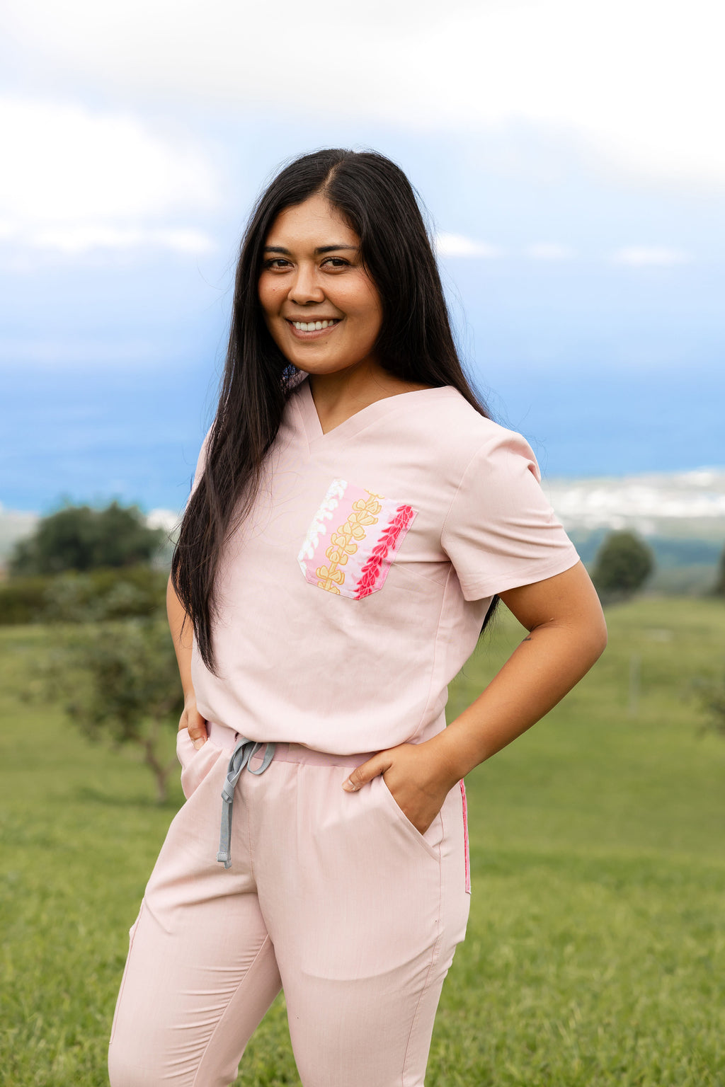 Woman wearing pink medical scrub set featuring pink Hawaii inspired floral design