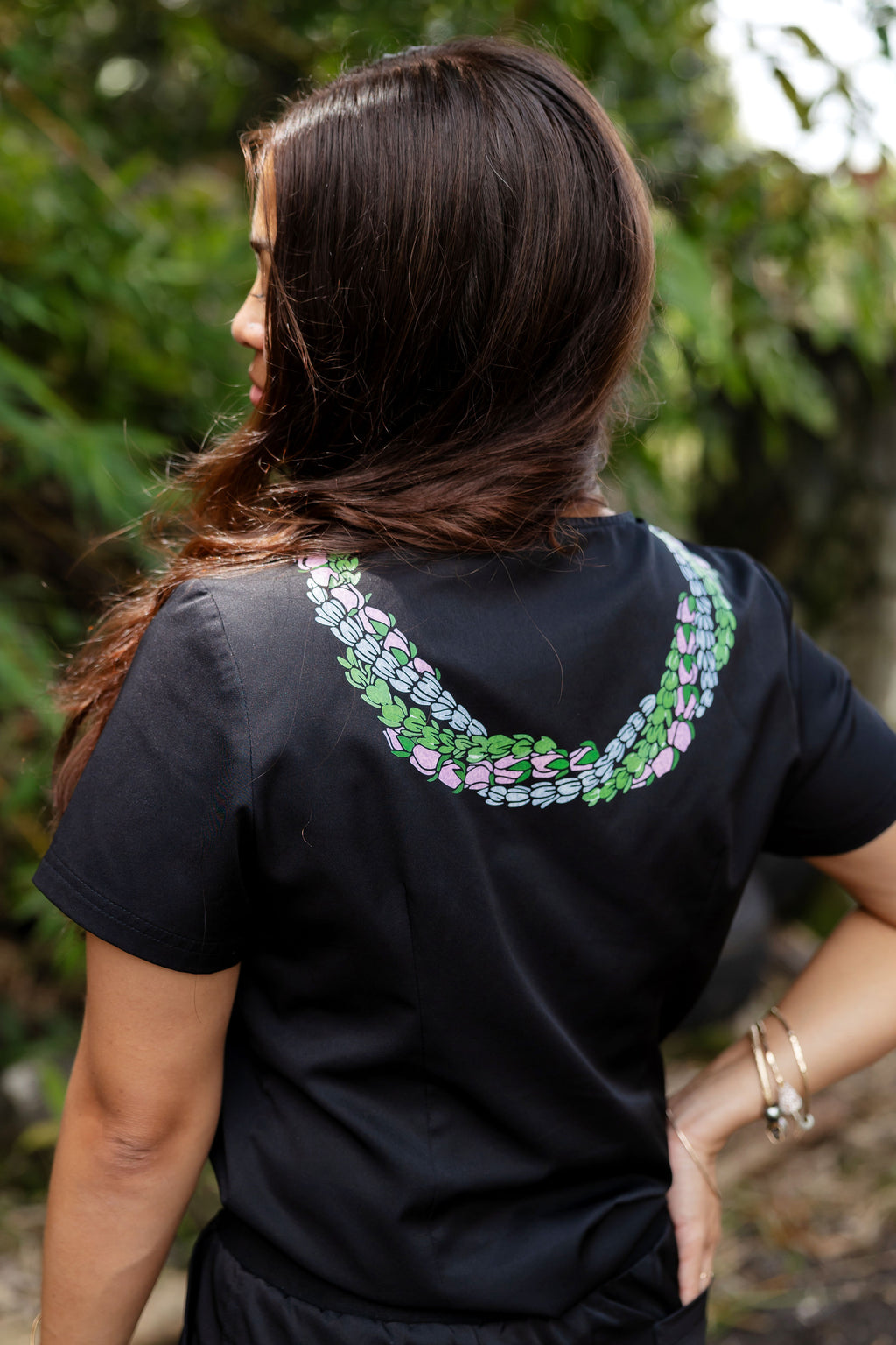 Back view of woman wearing medical scrub top with Hawaii inspired lei design