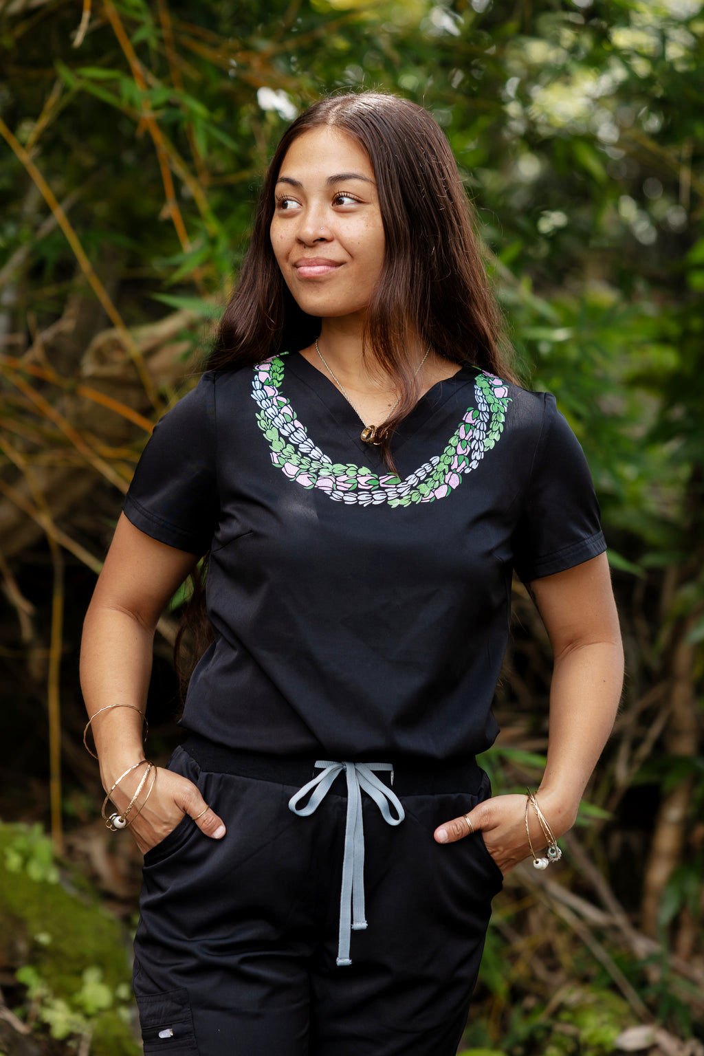 Woman wearing medical scrub top with Hawaii inspired lei design